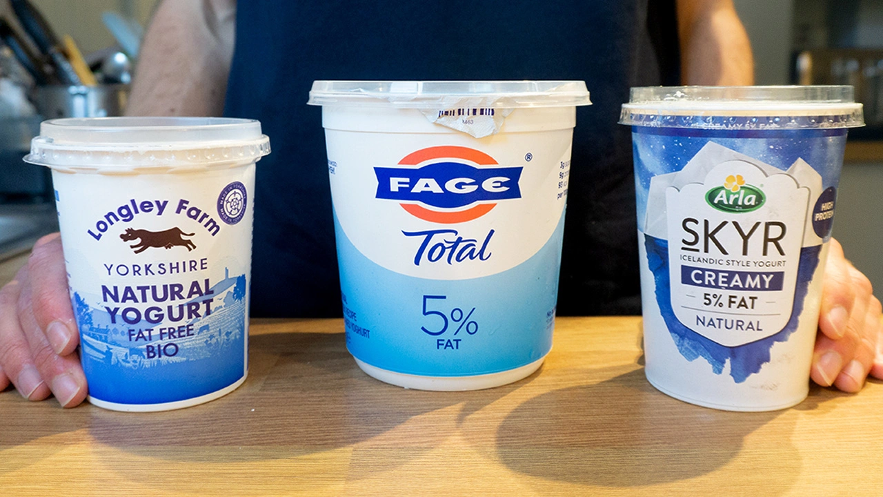 Three yogurt containers labeled Natural Yorkshire Yogurt, FAGE Total 5% Fat Greek Yogurt, and Arla Skyr Icelandic Style Yogurt on a table.